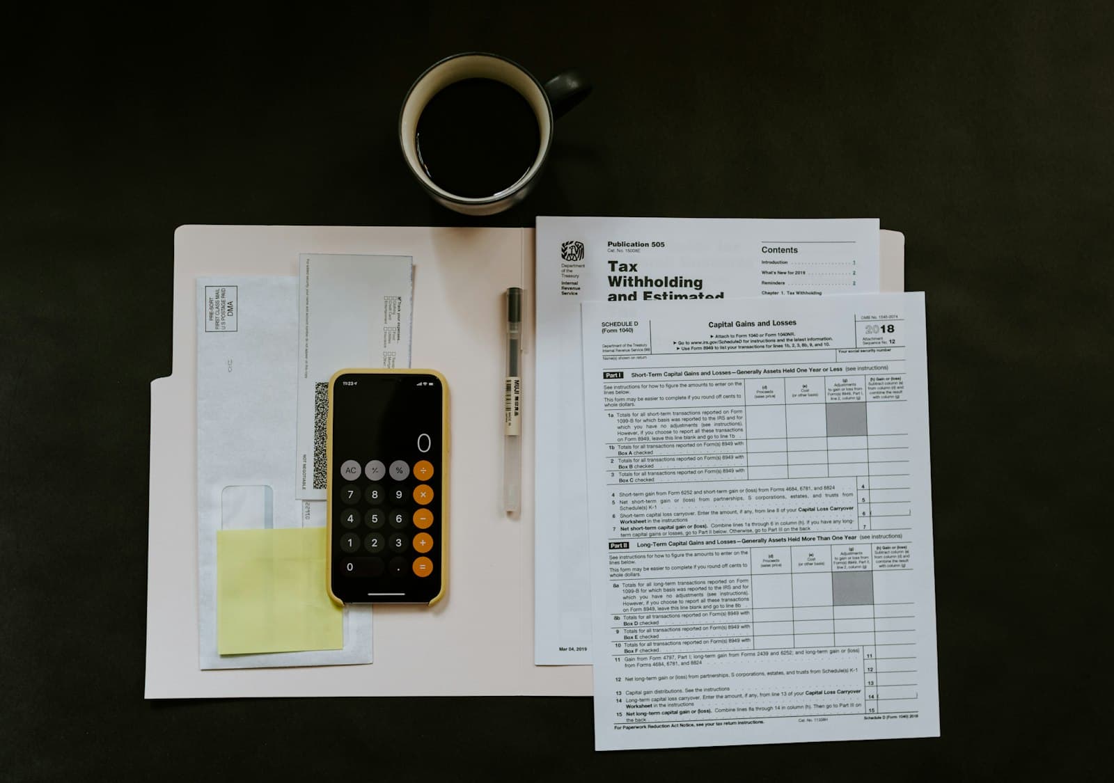 A tax form, calculator and coffee on a desk during payroll